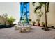 Picturesque courtyard featuring brick pavers, a stone table, and mature landscaping at 612 Bird Bay S Dr # 116, Venice, FL 34285