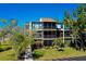 Three-story condo building with screened lanais and lush landscaping at 612 Bird Bay S Dr # 116, Venice, FL 34285