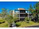 An aerial view of the condominium building exterior shows balconies and lush landscaping at 612 Bird Bay S Dr # 116, Venice, FL 34285