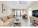 Bright living room with a comfy sofa, a ceiling fan, and sliding doors to a balcony at 612 Bird Bay S Dr # 116, Venice, FL 34285