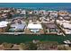 An aerial shot showcases waterfront homes along canal with private docks and the sparkling ocean in the background, exuding coastal living at 618 Gladstone Ln, Holmes Beach, FL 34217