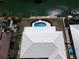 Aerial view of a home's roof, with a pool, dock and lush landscaping at 618 Gladstone Ln, Holmes Beach, FL 34217