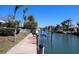 Waterfront property featuring a private dock with boat lift, lush landscaping, and canal access in a tropical setting at 618 Gladstone Ln, Holmes Beach, FL 34217