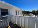 Side exterior angle of a white house with white fences and partial view of canal at 618 Gladstone Ln, Holmes Beach, FL 34217
