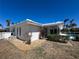Exterior view of the house with white walls, a white roof, a screened lanai and lush landscaping at 618 Gladstone Ln, Holmes Beach, FL 34217