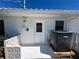 Exterior shot featuring the side of the home with utilities and a white door at 618 Gladstone Ln, Holmes Beach, FL 34217