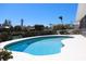 View of the kidney shaped pool surrounded by lush bushes and landscaping at 618 Gladstone Ln, Holmes Beach, FL 34217