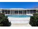 Backyard pool with screen porch, tropical landscaping, and access to the home, perfect for outdoor entertaining at 618 Gladstone Ln, Holmes Beach, FL 34217