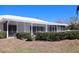 Rear view of property with a screened in porch and manicured landscaping at 618 Gladstone Ln, Holmes Beach, FL 34217