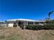 Rear exterior view with a screened porch and landscaping at 618 Gladstone Ln, Holmes Beach, FL 34217