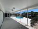 View of the pool and dock from the screened-in lanai with ceiling fans at 618 Gladstone Ln, Holmes Beach, FL 34217
