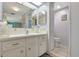 Bathroom includes a white vanity with a mirror and cabinetry, plus a toilet and a window providing natural light at 633 Cervina S Dr, Venice, FL 34285