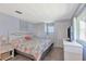 Cozy bedroom with blue walls, carpeted floors, a queen bed with floral print, and a TV on the dresser at 633 Cervina S Dr, Venice, FL 34285