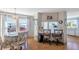 Cozy dining room featuring wood floors, a quaint table setting, and an open view into the adjacent kitchen at 633 Cervina S Dr, Venice, FL 34285