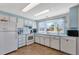 Bright kitchen features white appliances, blue accents and ample counter space for meal preparation at 633 Cervina S Dr, Venice, FL 34285