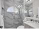 Modern bathroom featuring a glass enclosed shower with stylish marble tile surround and a decorative half-moon window at 6540 The Masters Ave, Lakewood Ranch, FL 34202