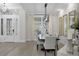 Formal dining room showcasing modern lighting, neutral decor, and a view of the front door at 6540 The Masters Ave, Lakewood Ranch, FL 34202
