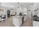 Open concept kitchen with island, white cabinets, stainless steel appliances, and views to the living area at 6540 The Masters Ave, Lakewood Ranch, FL 34202