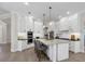 Bright kitchen with white cabinetry, stainless steel appliances, island seating, and modern pendant lighting at 6540 The Masters Ave, Lakewood Ranch, FL 34202
