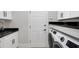 Modern laundry room featuring new washer and dryer, dark countertop, and white cabinets at 6540 The Masters Ave, Lakewood Ranch, FL 34202