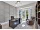 Elegant home office featuring custom wall paneling, large windows offering scenic views, and stylish, comfortable furnishings at 6540 The Masters Ave, Lakewood Ranch, FL 34202