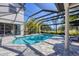 Sparkling pool and spa surrounded by a screened enclosure, lush landscaping, and inviting patio at 6540 The Masters Ave, Lakewood Ranch, FL 34202
