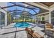 Spacious screened-in pool area featuring a hot tub and comfortable outdoor furniture at 6540 The Masters Ave, Lakewood Ranch, FL 34202
