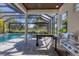 Relaxing pool area overlooking serene lake with outdoor seating and a built-in grill at 6540 The Masters Ave, Lakewood Ranch, FL 34202