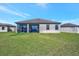 Rear exterior view showcases the home's screened lanai and expansive backyard, ideal for entertaining at 6620 35Th E Ct, Sarasota, FL 34243