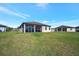 Rear exterior view displays a screened-in lanai and green yard with fencing in a community setting at 6620 35Th E Ct, Sarasota, FL 34243