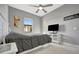 Bedroom with neutral walls, ceiling fan, white tile flooring, and modern furnishings at 6620 35Th E Ct, Sarasota, FL 34243