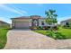 Beautiful one-story home featuring a manicured lawn and brick-paved driveway leading to a two-car garage at 6620 35Th E Ct, Sarasota, FL 34243