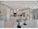 A bright kitchen with white cabinets, marble countertops, stainless steel appliances, and an island with seating at 6620 35Th E Ct, Sarasota, FL 34243