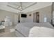 This modern main bedroom has light gray walls, white trim, tray ceiling, ceiling fan, and tile floors at 6620 35Th E Ct, Sarasota, FL 34243