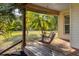 Relaxing porch featuring a wooden swing, natural wood decking, and a view of the lush landscape at 6838 Rabbit Ave, North Port, FL 34291