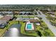 A serene community view showcasing a pool, tennis courts, and surrounding homes at 7102 42Nd E Ct, Sarasota, FL 34243