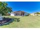 The back yard features a screened-in patio, manicured lawn, and mature trees providing ample shade at 7102 42Nd E Ct, Sarasota, FL 34243
