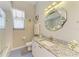 Charming bathroom with geometric mirror, granite countertop, and tile flooring plus a bathtub shower combination at 7102 42Nd E Ct, Sarasota, FL 34243