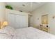 Cozy bedroom featuring white closet doors, light colored walls, ceiling fan, and a bed with tufted headboard at 7102 42Nd E Ct, Sarasota, FL 34243