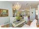 Elegant dining room features glass table, seating for four, and a view into the living room at 7102 42Nd E Ct, Sarasota, FL 34243
