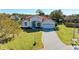 Charming front exterior with tile roof, arched entryway, well-maintained lawn, and a paver driveway at 7102 42Nd E Ct, Sarasota, FL 34243