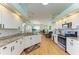 Open kitchen with white cabinetry, granite countertops, stainless appliances, and adjoining living area at 7102 42Nd E Ct, Sarasota, FL 34243