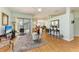 Open living room with views to a sliding glass door, dining room, and hardwood floors at 7102 42Nd E Ct, Sarasota, FL 34243