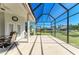 Spacious screened-in patio overlooking a lush lawn, pond, and surrounding homes, perfect for outdoor living at 7102 42Nd E Ct, Sarasota, FL 34243