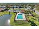 An aerial view of a community pool near a pond, surrounded by lush landscaping at 7102 42Nd E Ct, Sarasota, FL 34243