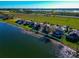 Aerial view of home with fenced backyard, backing onto a lake with a lawn area and trees at 718 Tanana Fall Dr, Ruskin, FL 33570