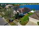 Lakeside single-story home with a well-manicured lawn and mature trees in a residential neighborhood at 718 Tanana Fall Dr, Ruskin, FL 33570