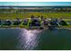 Aerial view of the lakefront home features fenced backyard, waterfront view, and lakeside landscaping at 718 Tanana Fall Dr, Ruskin, FL 33570