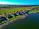 An aerial shot showcases waterfront homes on a lake, each with beautiful landscaping and curb appeal at 718 Tanana Fall Dr, Ruskin, FL 33570