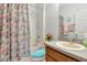 Bathroom with a shower featuring a floral print curtain, and a sink with a wooden vanity at 718 Tanana Fall Dr, Ruskin, FL 33570